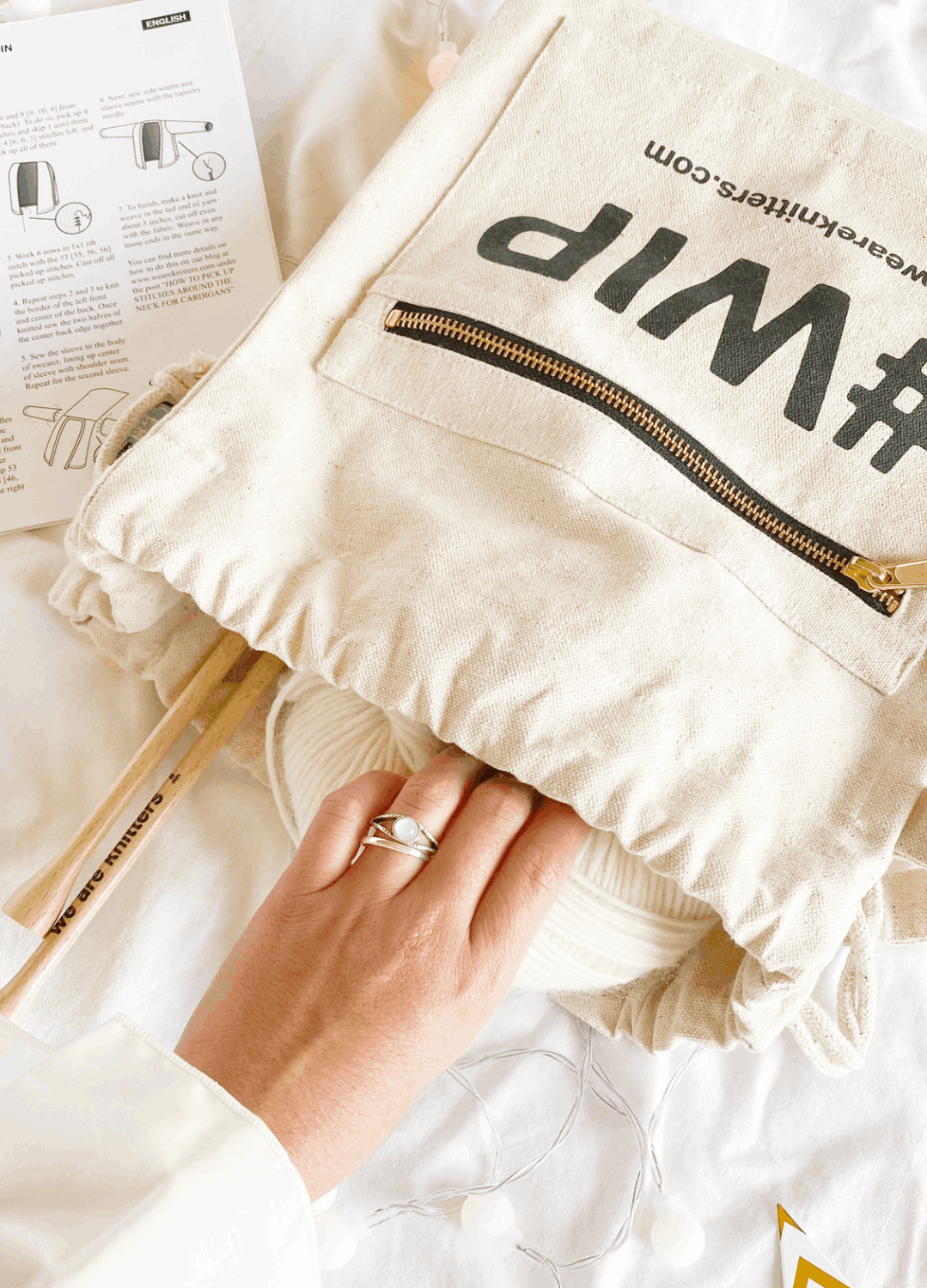 The #WIP Bag front zip pocket, shown with we are knitters wooden needles and the printed pattern