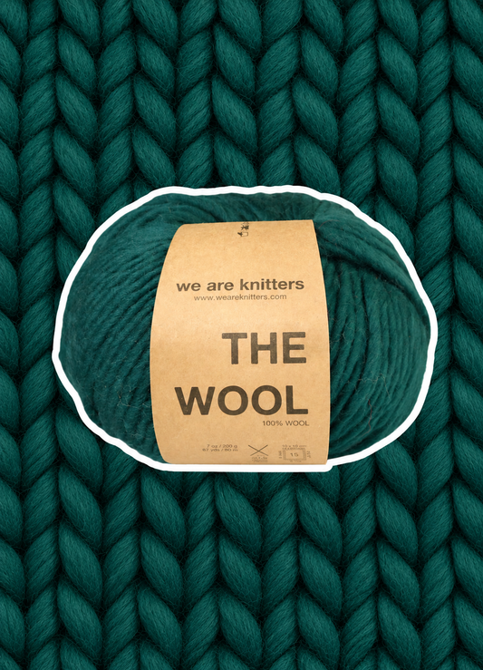 The Wool Forest Green yarn ball on a matching knit swatch
